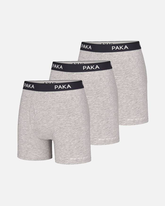 Front view of three-pack men’s Essential Boxer Briefs in heather grey with black PAKA branded waistbands on light gray background