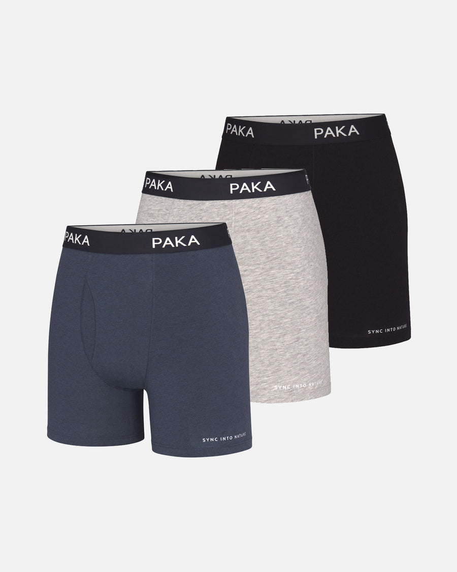 Front view of 3-pack men’s boxer briefs (navy, heather gray, black) showing PAKA branded elastic waistbands on pale gray background