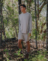 Man wearing alpaca terry crew and terry shorts walking through woods 