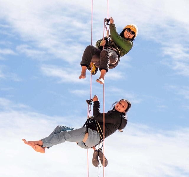 Two women suspended from a great height smiling