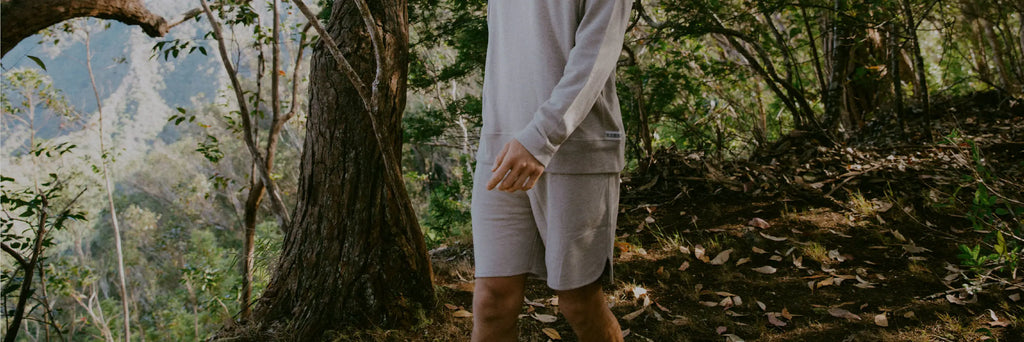 Man walking on a forest trail wearing tri-blend alpaca terry crew and matching terry shorts