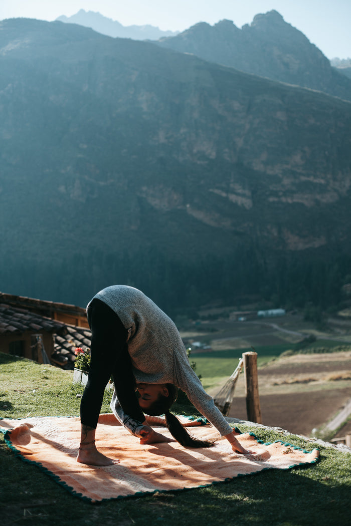 Woman Model doing yoga in the Costa alpaca sweater by Paka Apparel