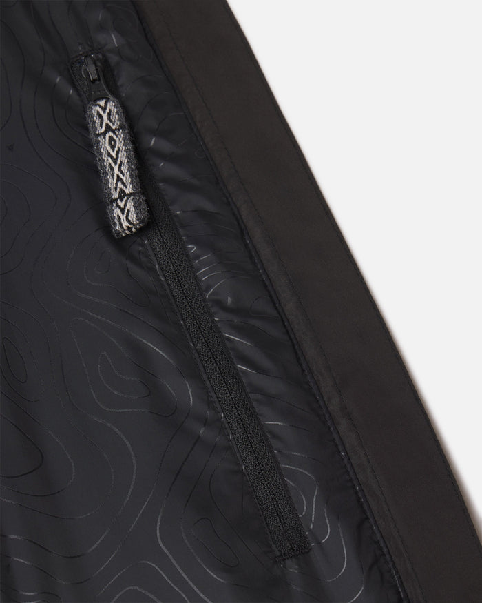 Close-up of women’s PAKAFILL Midweight Puffer interior showing zippered pocket with patterned pull tab on black lining