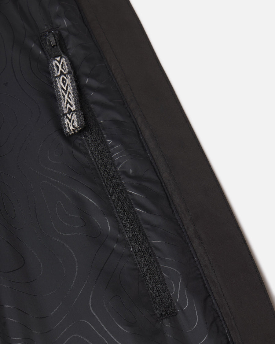 Close-up of women’s PAKAFILL Midweight Puffer interior showing zippered pocket with patterned pull tab on black lining