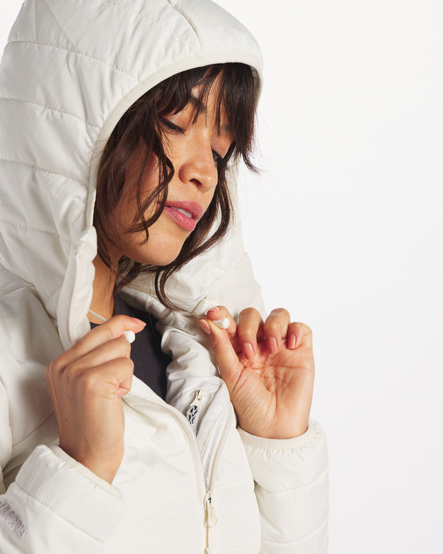 Close-up of Women’s PAKAFILL midweight puffer jacket showing hood, drawcord toggles, and zipper on white background