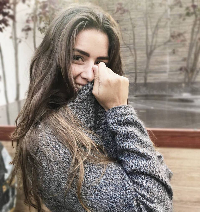 Three-quarter view of The Vida hoodie in marled gray on a model showing relaxed drapey fit and textured knit