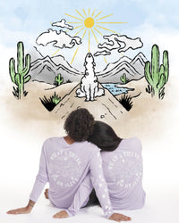 Back view of Sebastian Long Sleeve in lavender on two seated models, showing large alpaca graphic and paw-print sleeve details