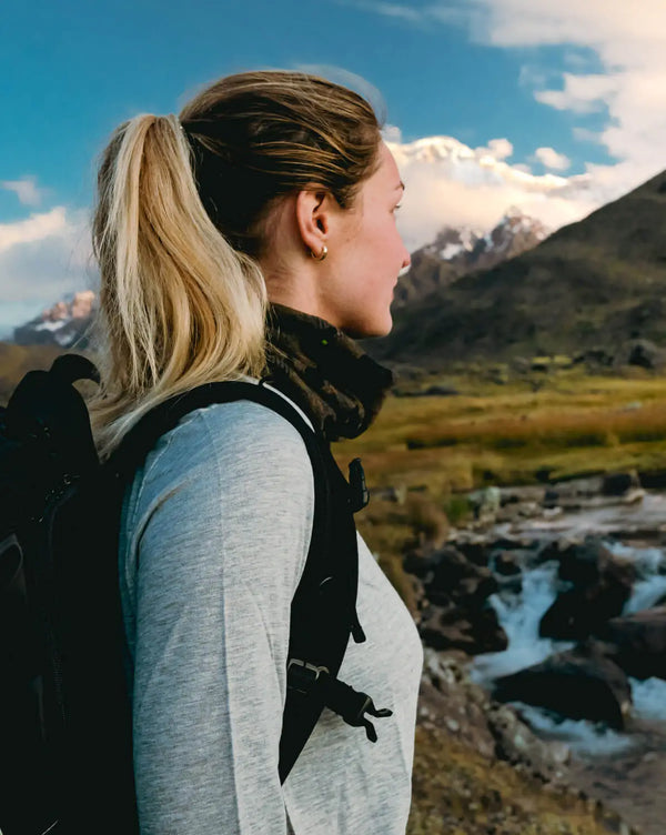 Close Up of Model in Heather Grey Aire Women's Hiking Long Sleeve Shirt in Front of Mountains – PAKA Apparel