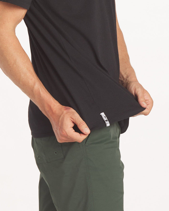 Close up of man holding the Men's Tee showing the tag